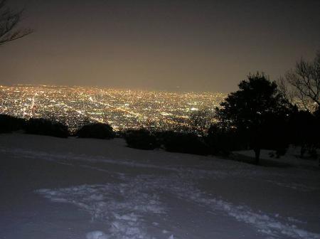 夜景の光で雪が輝いている