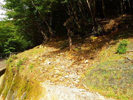この上に冷水山登山口と書かれた看板があって入山する。積みブロックの壁をのぼらないといけない