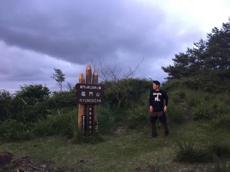 下る前に記念撮影してもらおうと思いきや、山頂看板に大きい蜘蛛がいてびっくり！そこをS嬢がすかさずパシャリとしたやつです