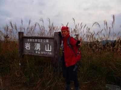 ススキの中で岩湧山山頂(897.7m)に到着。思わず記念撮影をとってもらった。すでに看板よりススキのほうが高い